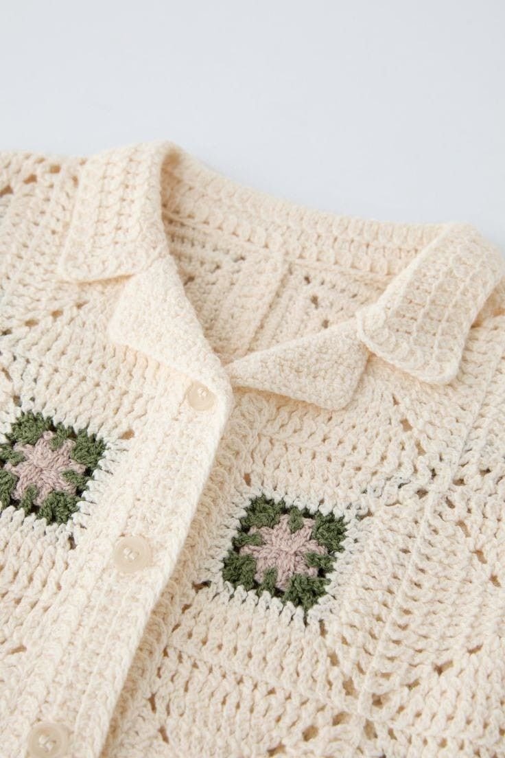 Detalhe da gola e dos pontos da camisa creme